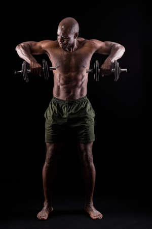 Front view of a muscular man standing doing triceps exerciseの写真素材