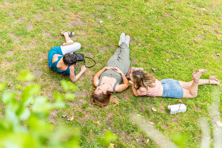 Middle-aged friends lying on the grass having a good time