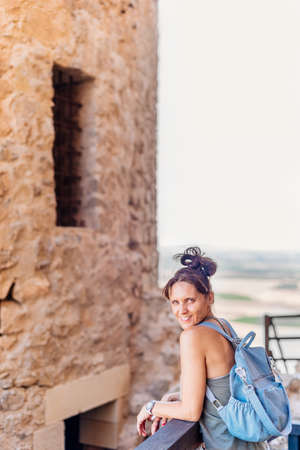 Woman leaning on a railing next to historic castleの写真素材