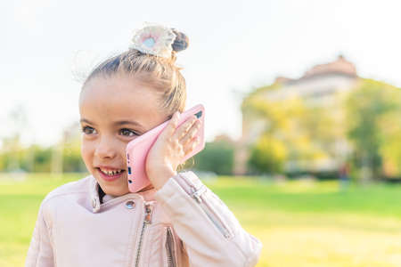 girl talking on smart phone in the parkの写真素材