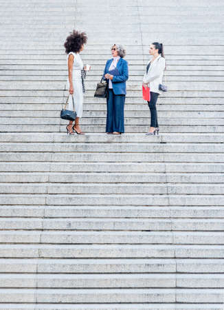co-workers talking in the middle of a granite staircase
