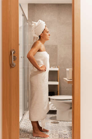 Full side view of an adult woman wrapped with towels.の写真素材