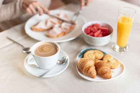 Coffee and croissant for breakfast served at a table.の写真素材