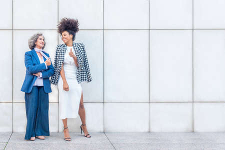 two women laughing while enjoying a break from workの写真素材