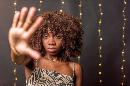African American woman showing palm looking at camera