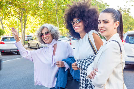 three businesswomen waiting for a taxi after a working day
