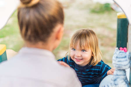 A little boy looking at his sister on the playground.の写真素材