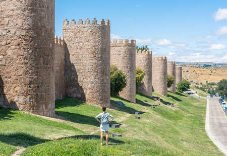 Woman standing near stone walls of cityの写真素材