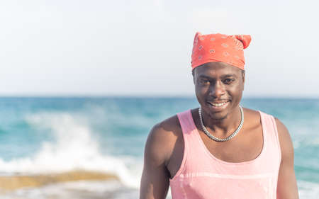 young African man posing in front of the seaの写真素材