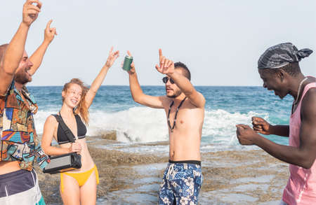 group of young people celebrating with music at the beach