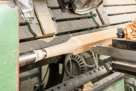 Professional machine turning wood detail in workshop