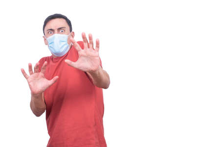 Scared man in medical mask with outstretched arms