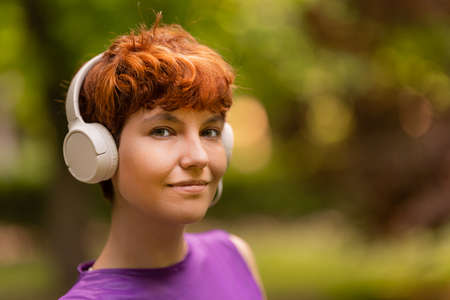 Non binary meloman listening to music in parkの写真素材