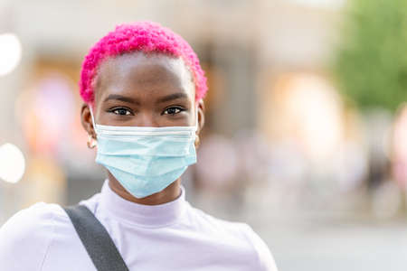 Young modern african woman wearing facial protective mask