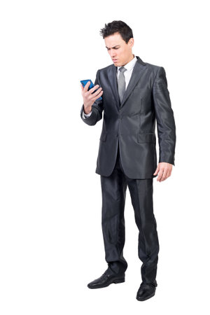 Worried man in suit reading message on smartphoneの写真素材