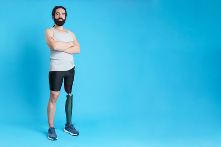 Man with a leg prosthesis standing with arms crossedの写真素材