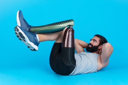 Man with a leg prosthesis doing abdominal crunchesの写真素材