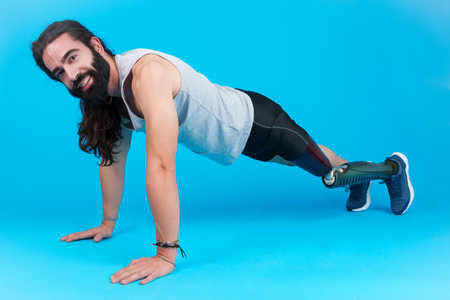 Man with a prosthetic leg doing push-ups on the floorの写真素材