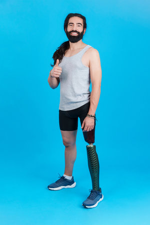 Smiley man with a prosthesis leg gesturing to be wellの写真素材