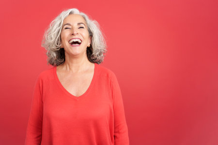 A happy mature woman laughing while standingの写真素材