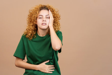 Woman gesturing and expressing headache and stomachacheの写真素材