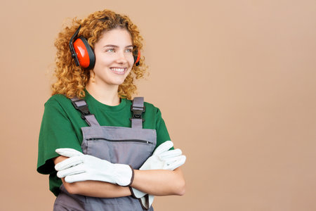 Distracted woman carpentry worker with tools and work uniformの写真素材