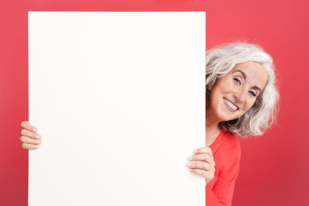 Smiley mature woman holding a blank panelの写真素材