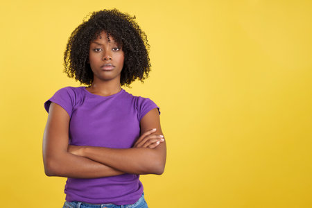 Angry woman with afro hair standing with arms crossedの写真素材