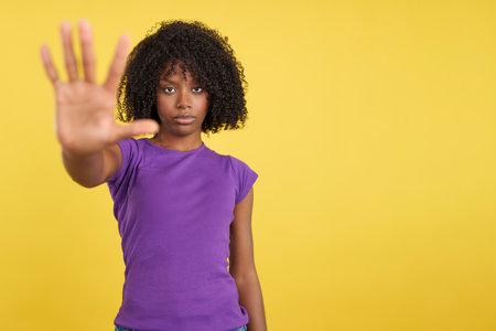 Serious woman with African hair gesturing rejectionの写真素材