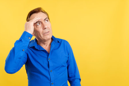 Mature man gesturing that he is forgetting somethingの写真素材