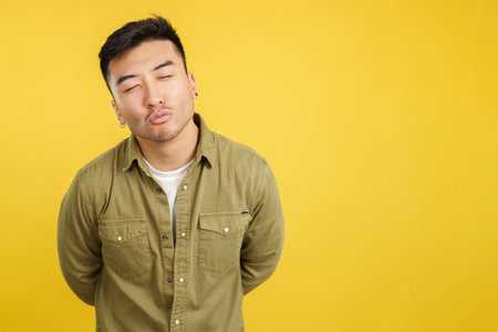 Chinese young man kissing with eyes closedの写真素材