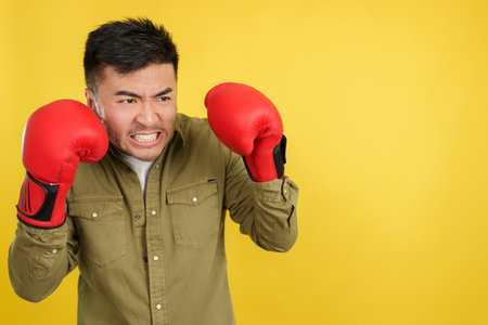Angry chinese man with boxing gloves with fighting pose