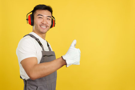 Chinese male carpenter gesturing approval with thumb upの写真素材