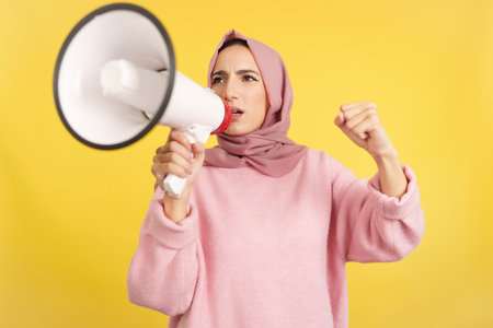 Upset muslim woman using a loudspeaker in angerの写真素材
