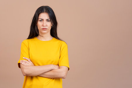 Hispanic woman crossing the arms with an angry expressionの写真素材