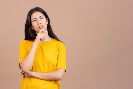 Woman with hand on face and thoughtful expressionの写真素材