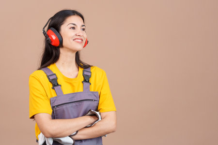 Distracted female carpenter looking away with arms crossedの写真素材