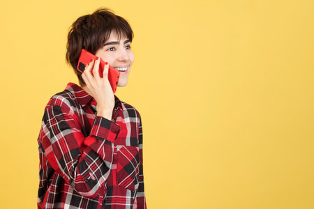 Happy androgynous person talking to the mobileの写真素材
