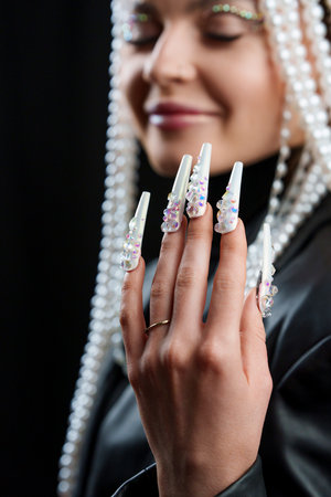 Hand of a woman with white fake nail extensionsの写真素材