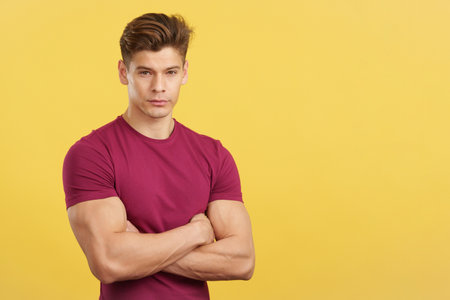 Serious man looking at camera with arms crossedの写真素材