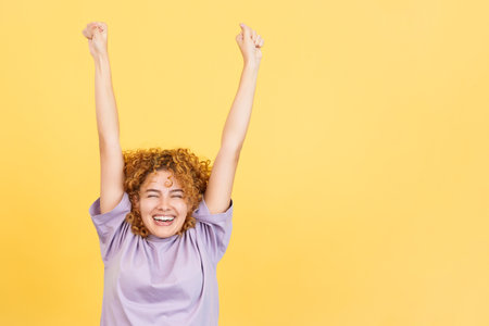 Woman celebrating while raising the arms and smilingの写真素材