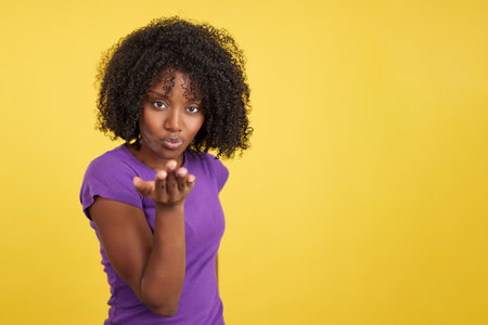 Sensual african woman blowing a kiss while looking at cameraの写真素材