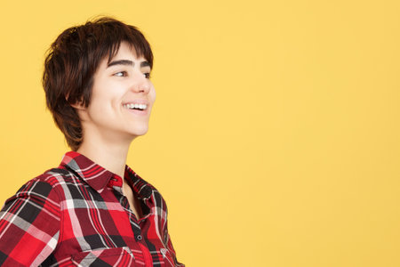 Distracted androgynous person smiling while looking awayの写真素材