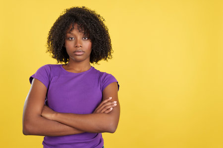 Angry woman with afro hair posing with arms crossedの写真素材