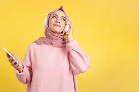 Happy muslim woman smiling while listening to musicの写真素材