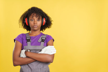 Afro female carpenter crossing arms with serious expressionの写真素材