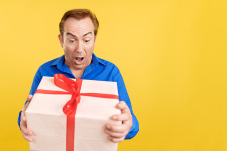 Happy mature man receiving a gift boxの写真素材