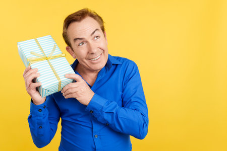 Curious mature man receiving a Fathers Day giftの写真素材