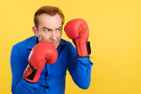 An angry mature man with boxing glovesの写真素材