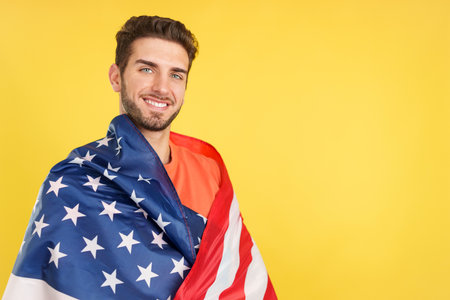 Happy caucasian man wrapping with a north america national flagの写真素材